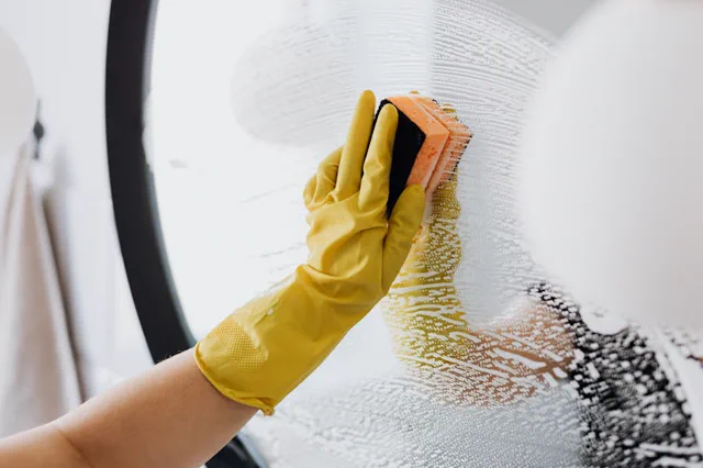 Person wiping a kitchen surface during kitchen cleaning